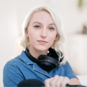 Portret van Dide Vonk met koptelefoon om haar nek en een rustige, neutrale uitdrukking.