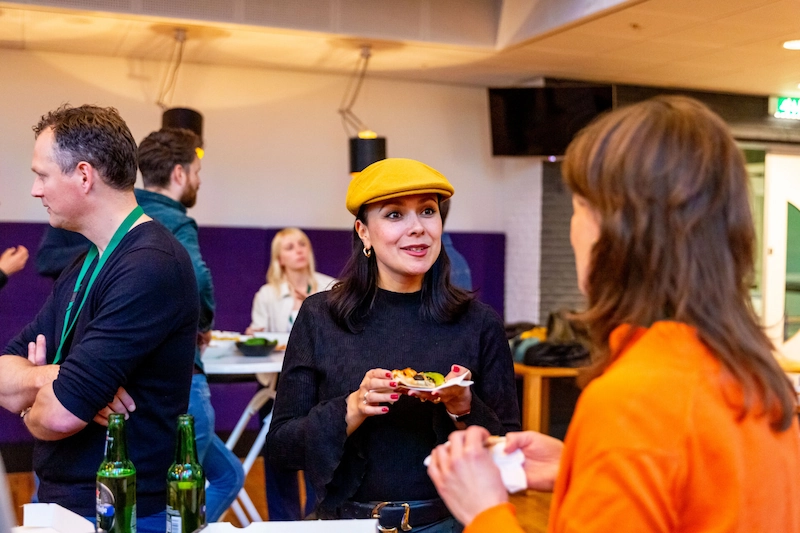 Bezoekers van de EarEar-community praten en eten tijdens een informele netwerksessie.