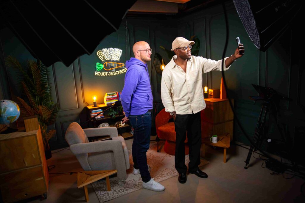 Twee mannen maken een selfie in de sfeervol ingerichte Groeivoer Podcast Studio in Utrecht.