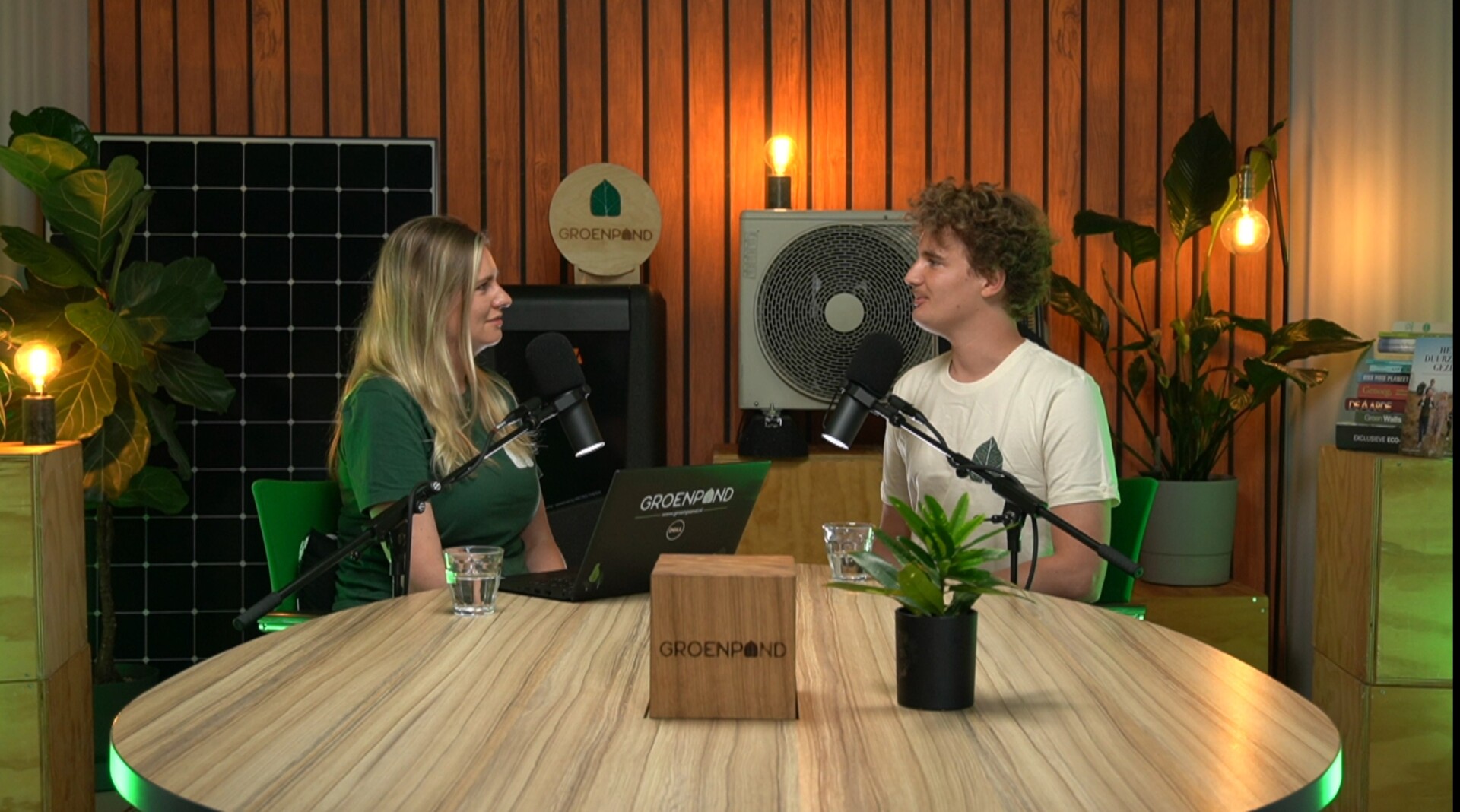 Twee mensen voeren een podcastgesprek in een duurzaam ingerichte studio van Groenpand.