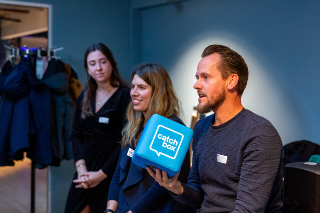 Man houdt een Catchbox-microfoon vast tijdens een panelgesprek bij TBI Prowcast met Lars Lensink.