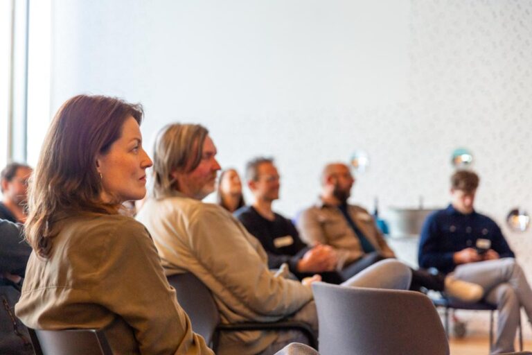 Bezoekers luisteren aandachtig tijdens een sessie van de All Ears Club bij NPO Luister.