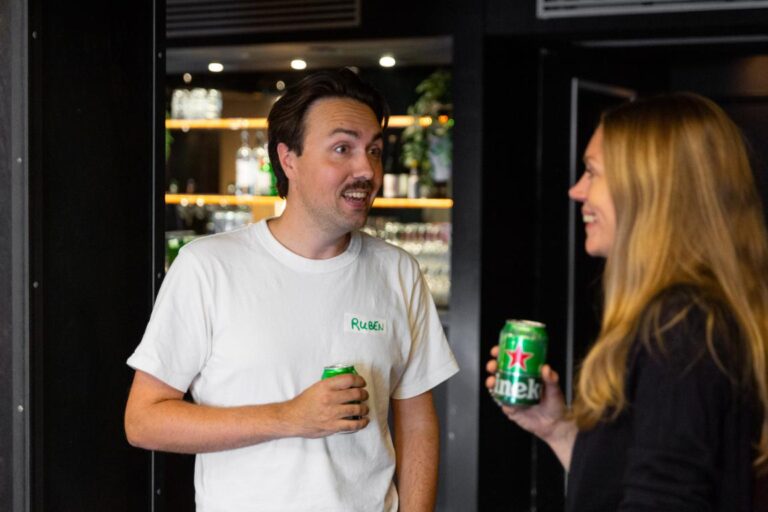 Twee mensen in gesprek met een blikje Heineken in de hand tijdens All Ears Club @ De Stroom.