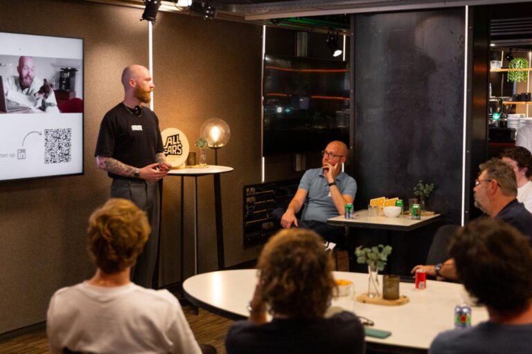 Een spreker presenteert voor een kleine groep luisteraars tijdens het All Ears Club-evenement bij De Stroom.