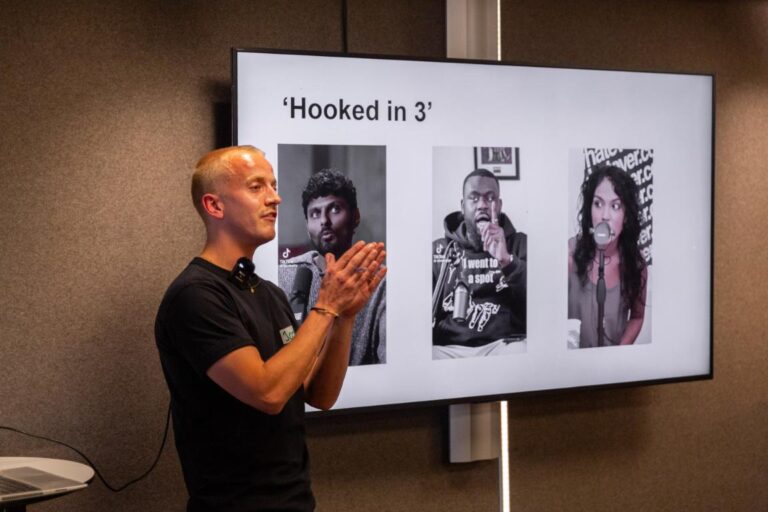 Spreker Lars Lensink presenteert bij All Ears Club een dia met de titel 'Hooked in 3' en drie portretten van podcasters op een scherm.